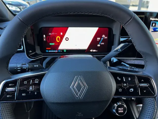 Vue rapprochée du volant et du combiné d'instruments numérique de la Renault R5 Techno 150 ch, affichage multifonctions allumé.