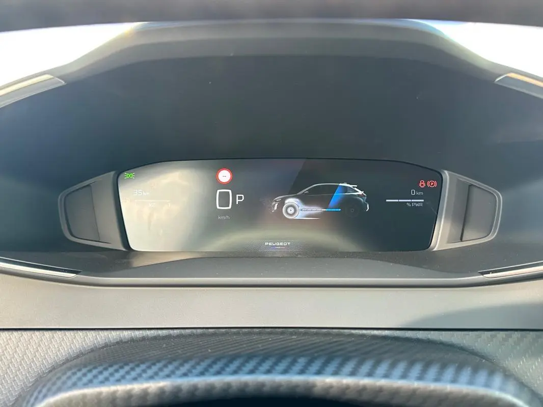 Vue rapprochée du cockpit numérique de la Peugeot 208 Hybrid 110 gris, affichant l'état du véhicule et la vitesse à 0 km/h.