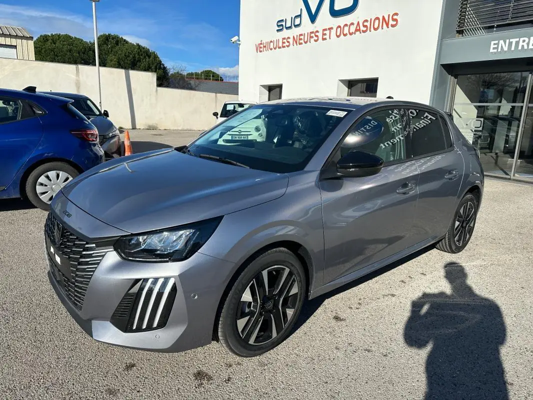 Peugeot 208 Hybrid gris vue 3/4 avant droit, jantes alliage 16 pouces et feux diurnes à LED distinctifs.