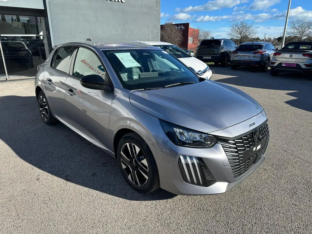 Peugeot 208 Hybrid gris vue 3/4 avant droit, avec calandre noire distinctive et jantes alliage 16 pouces.