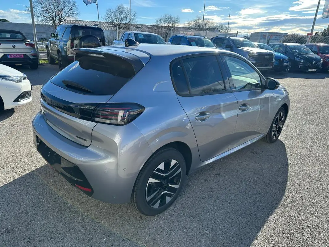 Peugeot 208 Hybrid gris vue 3/4 arrière droit, jantes alliage noires et toit avec antenne requin.
