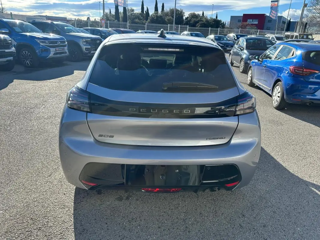 Vue arrière d'une Peugeot 208 Hybrid 110 gris métallisé, avec feux arrière noirs et logo Peugeot centré.