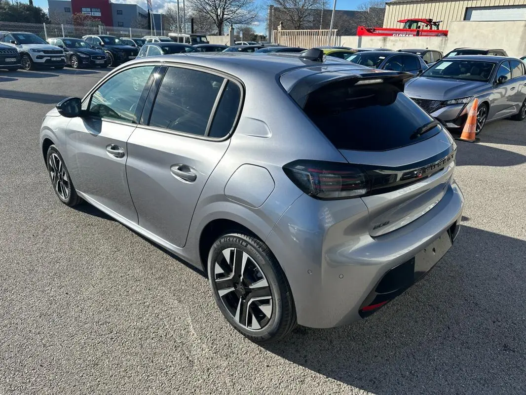 Peugeot 208 Hybrid gris vue 3/4 arrière droit, jantes alliage 16 pouces et vitres teintées.