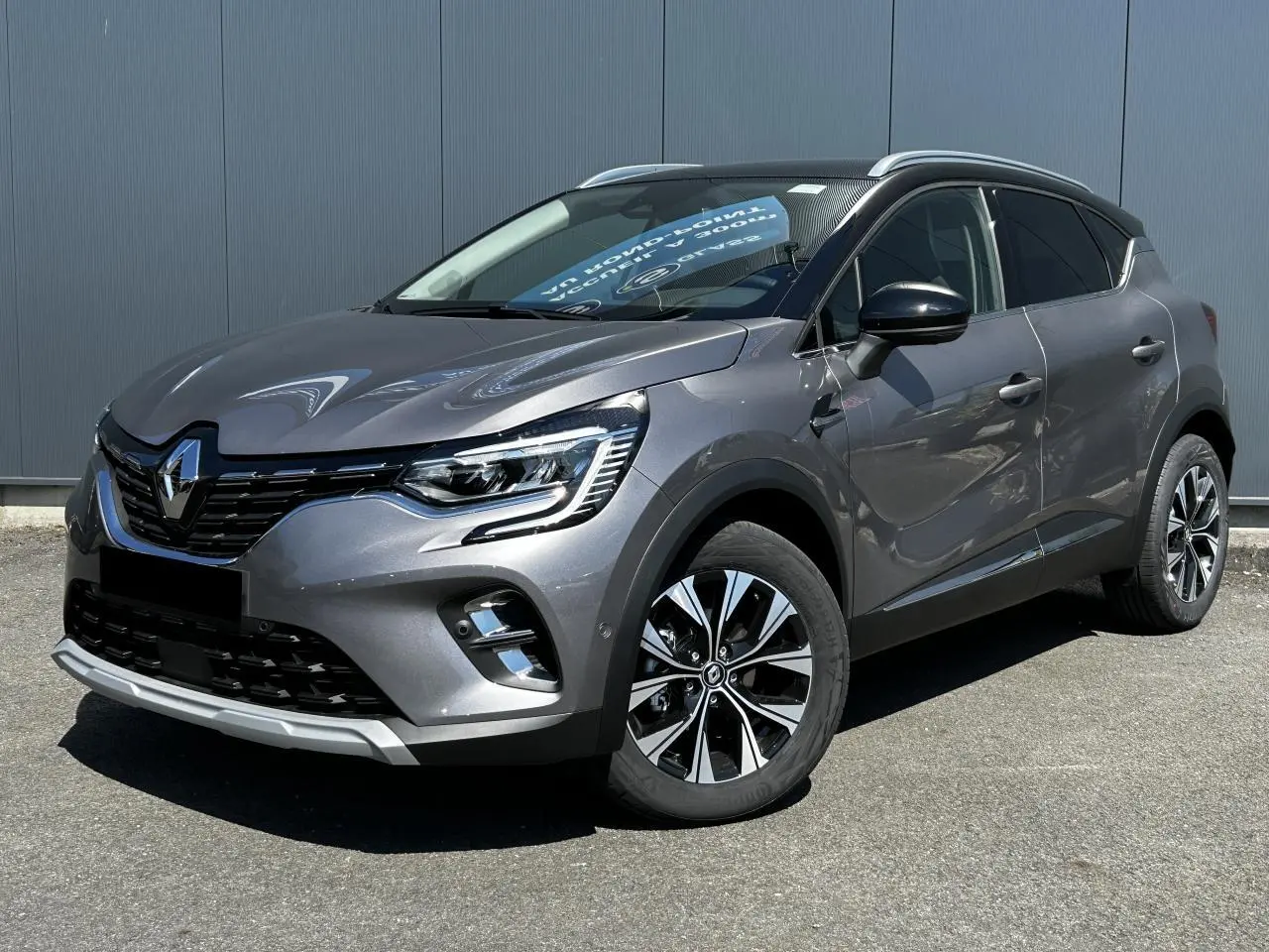 Renault Captur 2024 gris Cassiopée en 3/4 avant droit avec toit noir étoilé et jantes alliage 17 pouces.