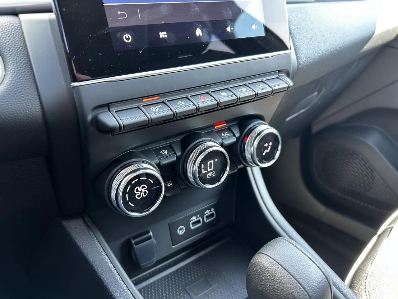 Vue rapprochée de la console centrale du Renault Captur 2024, montrant les commandes de climatisation et ports USB.