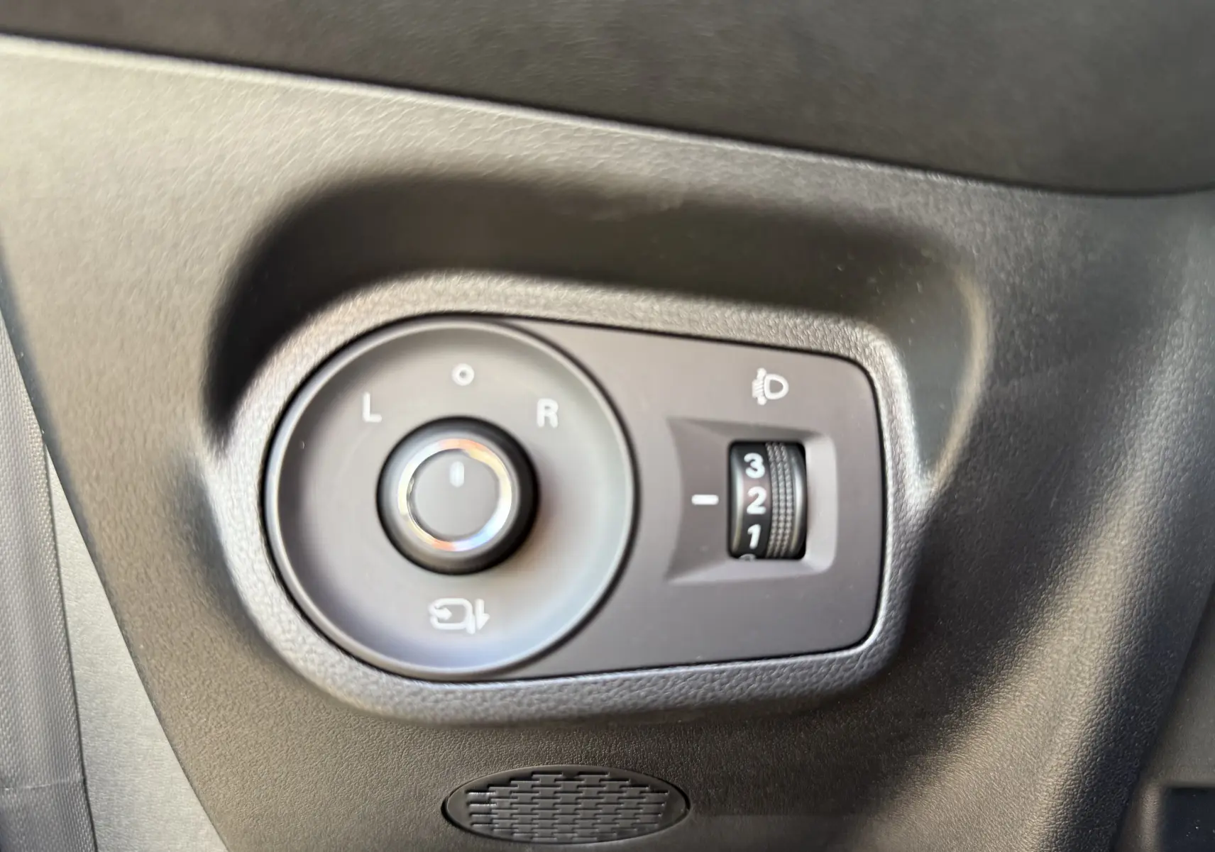 Gros plan sur les commandes de réglage des rétroviseurs et de l’éclairage, côté gauche intérieur d’une MG3 noire.