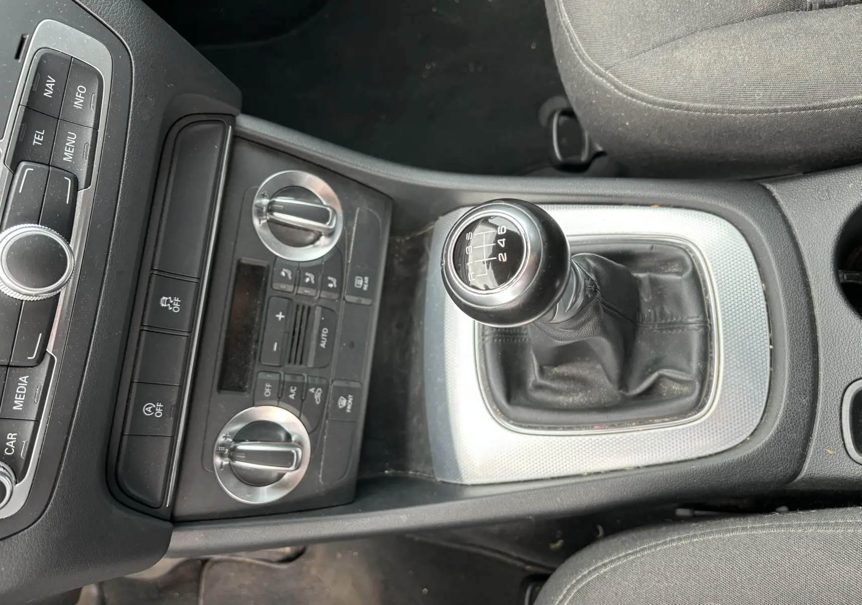 Vue plongeante sur la console centrale d'un Audi Q3 noir 2014, mettant en valeur le levier de vitesse manuel à six rapports.