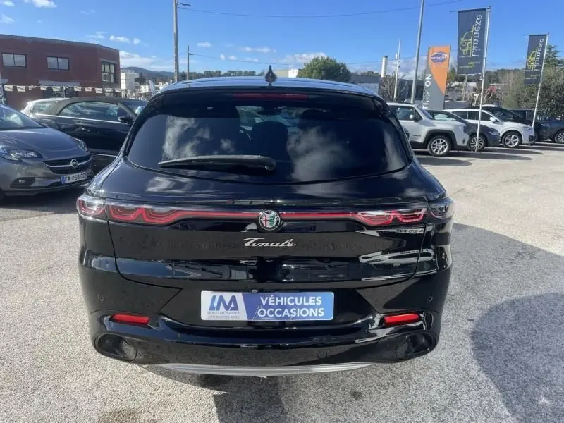 Vue arrière d'une Alfa Romeo Tonale noire 2023 avec feux LED distinctifs et badge e-Q4 sur parking extérieur.