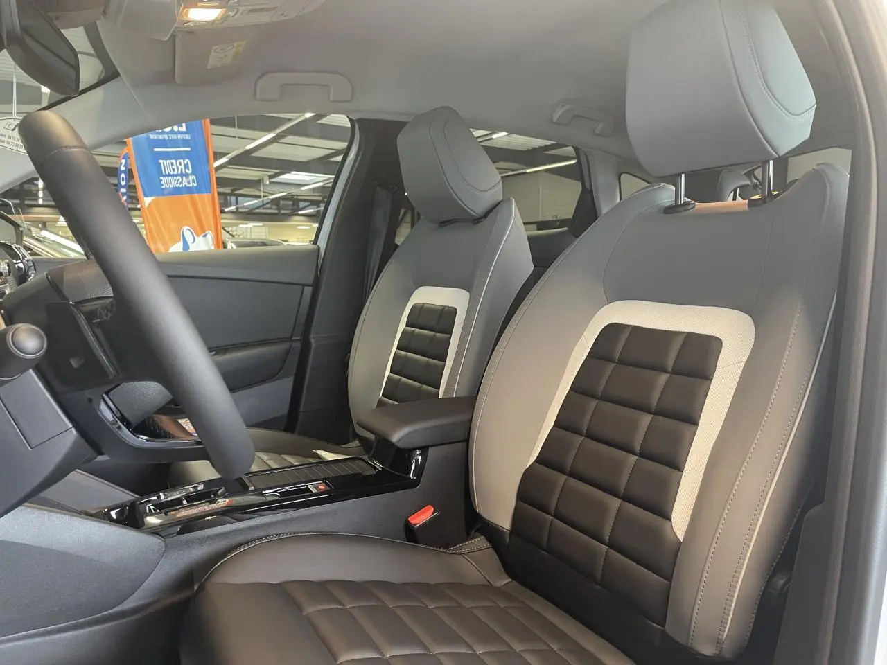 Vue intérieure côté conducteur de la Citroën C4 2025, sièges Advanced Comfort bicolores noir et gris clair.