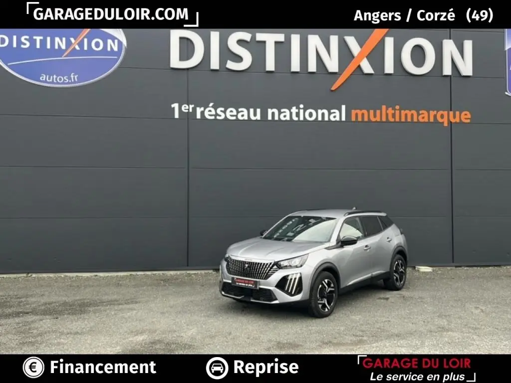 Peugeot 2008 Hybrid gris clair vue 3/4 avant droit, avec calandre distinctive et jantes noires stylisées.