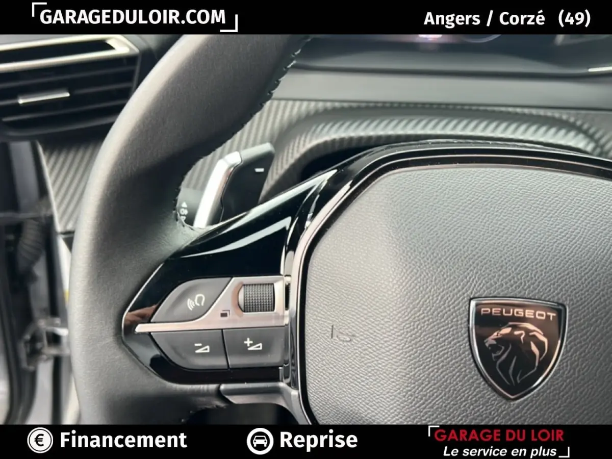 Gros plan sur le volant noir du Peugeot 2008 Hybrid 136 e-DCS6 Allure 2025 avec logo lion et commandes intégrées.