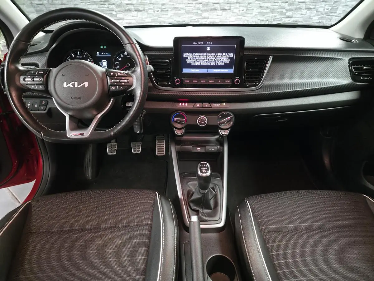 Vue intérieure avant de la Kia Rio GT Line 2022, volant cuir GT, écran tactile 8 pouces et levier de vitesses manuel.