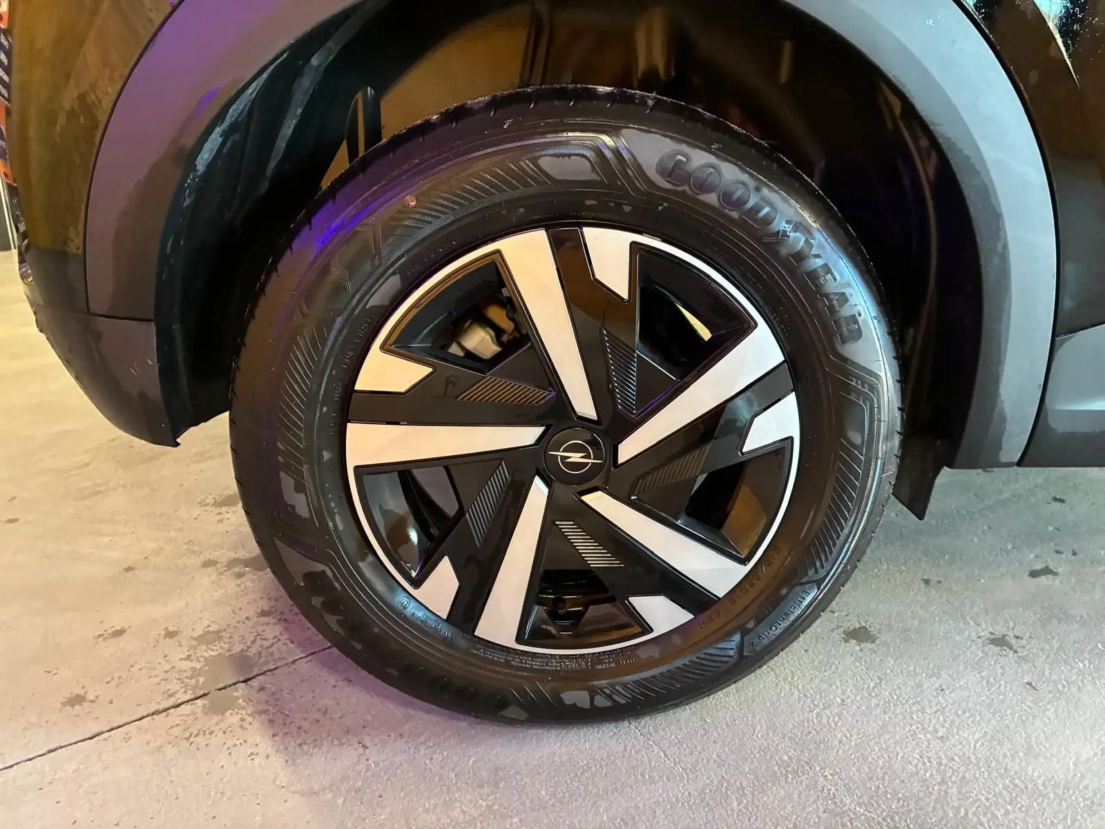 Gros plan sur la roue avant droite noire de l’Opel Mokka 1.2 Turbo 145 Edition avec jante alliage bicolore et pneu Goodyear.