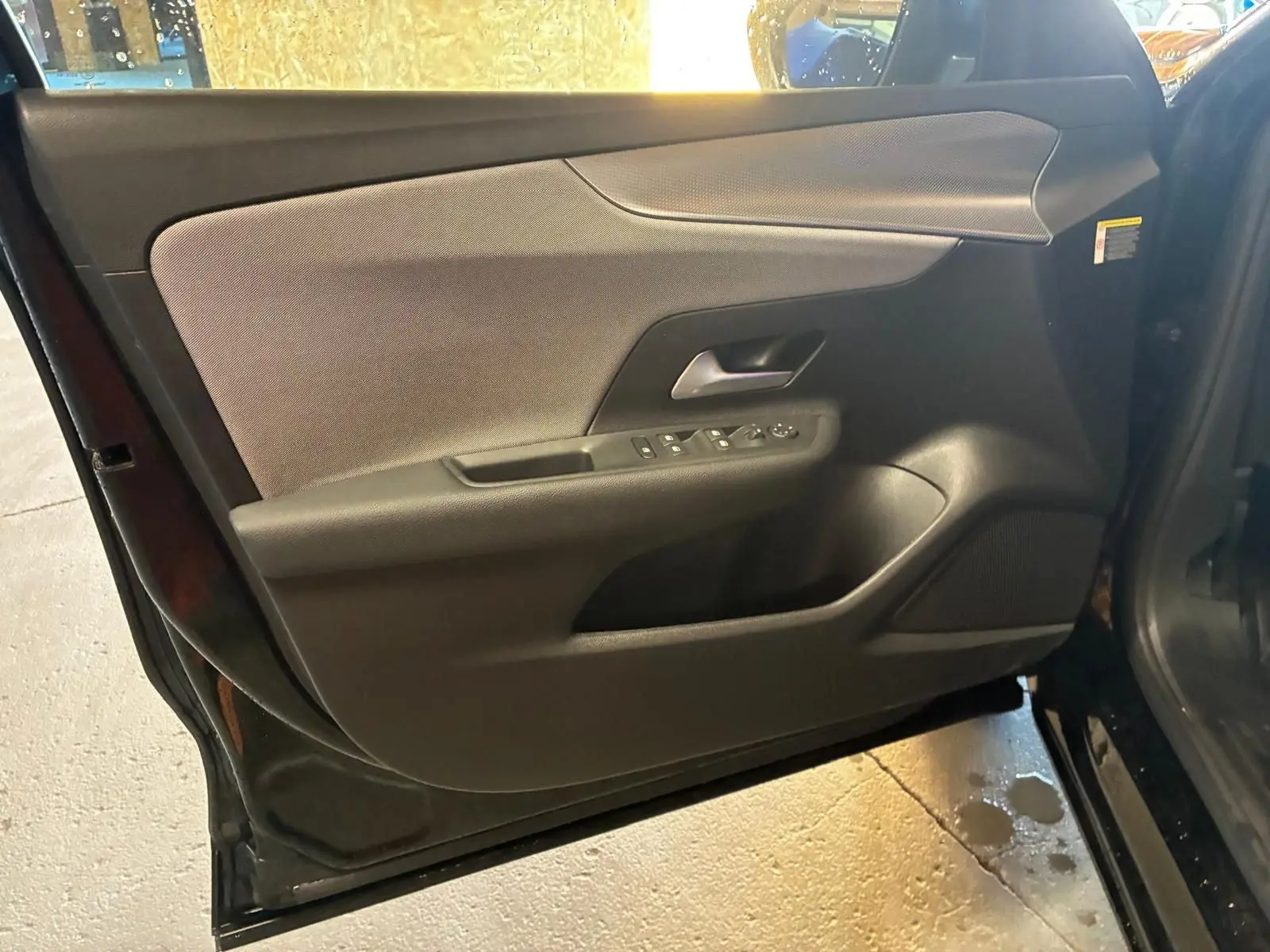 Vue intérieure de la porte avant gauche noire de l’Opel Mokka 1.2 Turbo 145 Edition avec commandes de vitres et poignée intégrée.