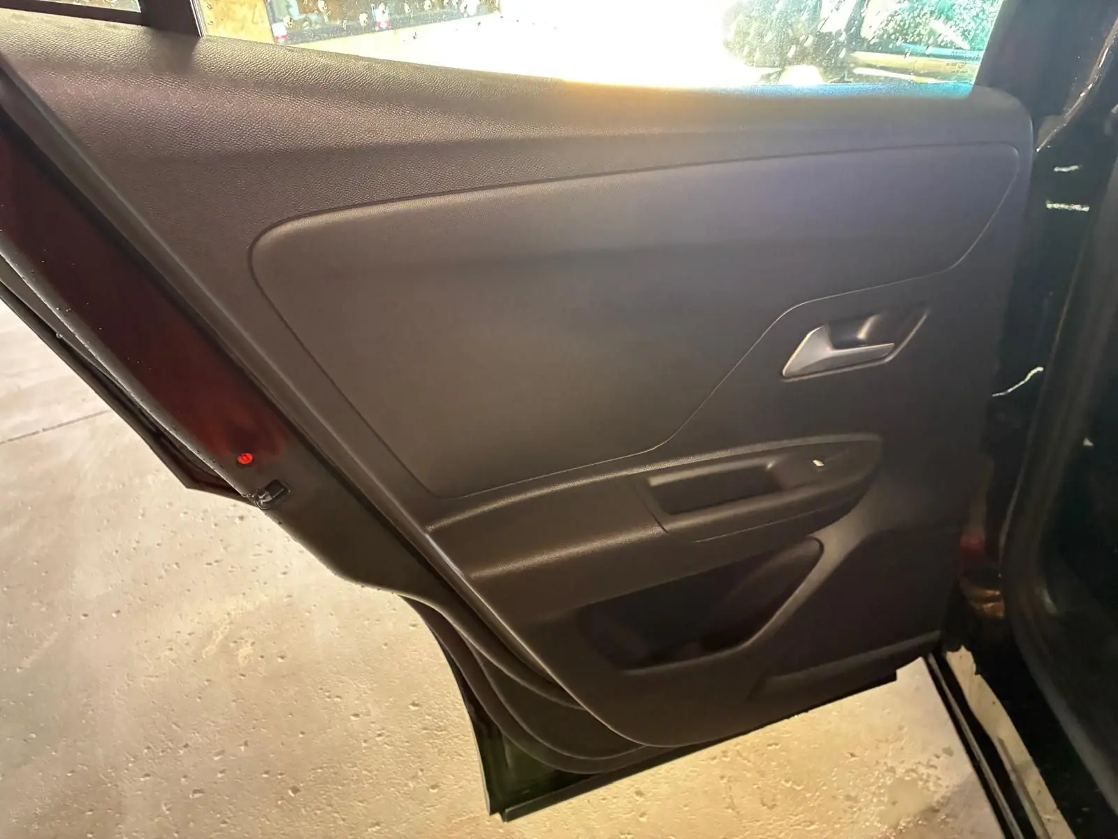 Intérieur de la porte arrière gauche noire de l’Opel Mokka 1.2 Turbo 145 Edition 2025, avec poignée argentée et commande de vitre.