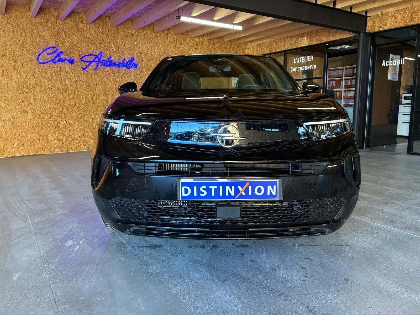 Vue frontale d'un Opel Mokka 1.2 Turbo 145 Edition noir brillant, avec calandre moderne et logo Opel éclairé.