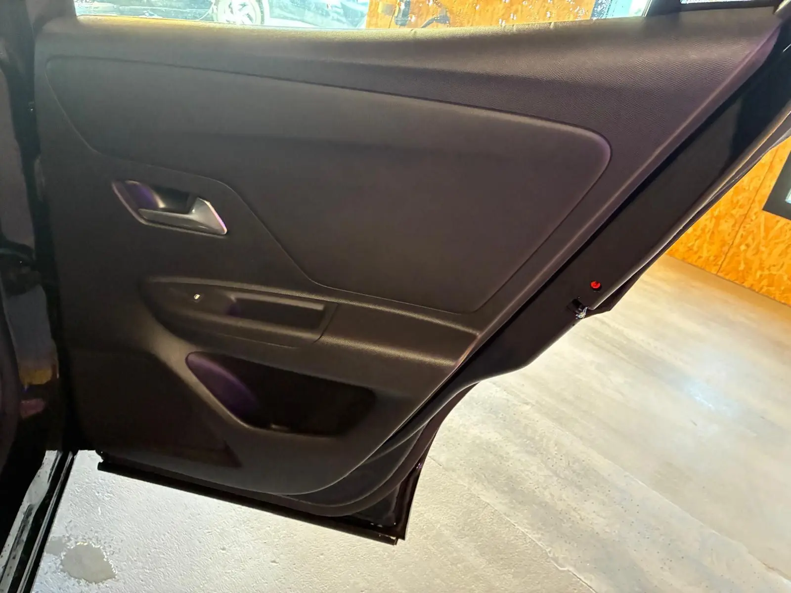 Vue rapprochée de la porte arrière gauche noire de l’Opel Mokka 2025, mettant en valeur la poignée intérieure et les rangements.