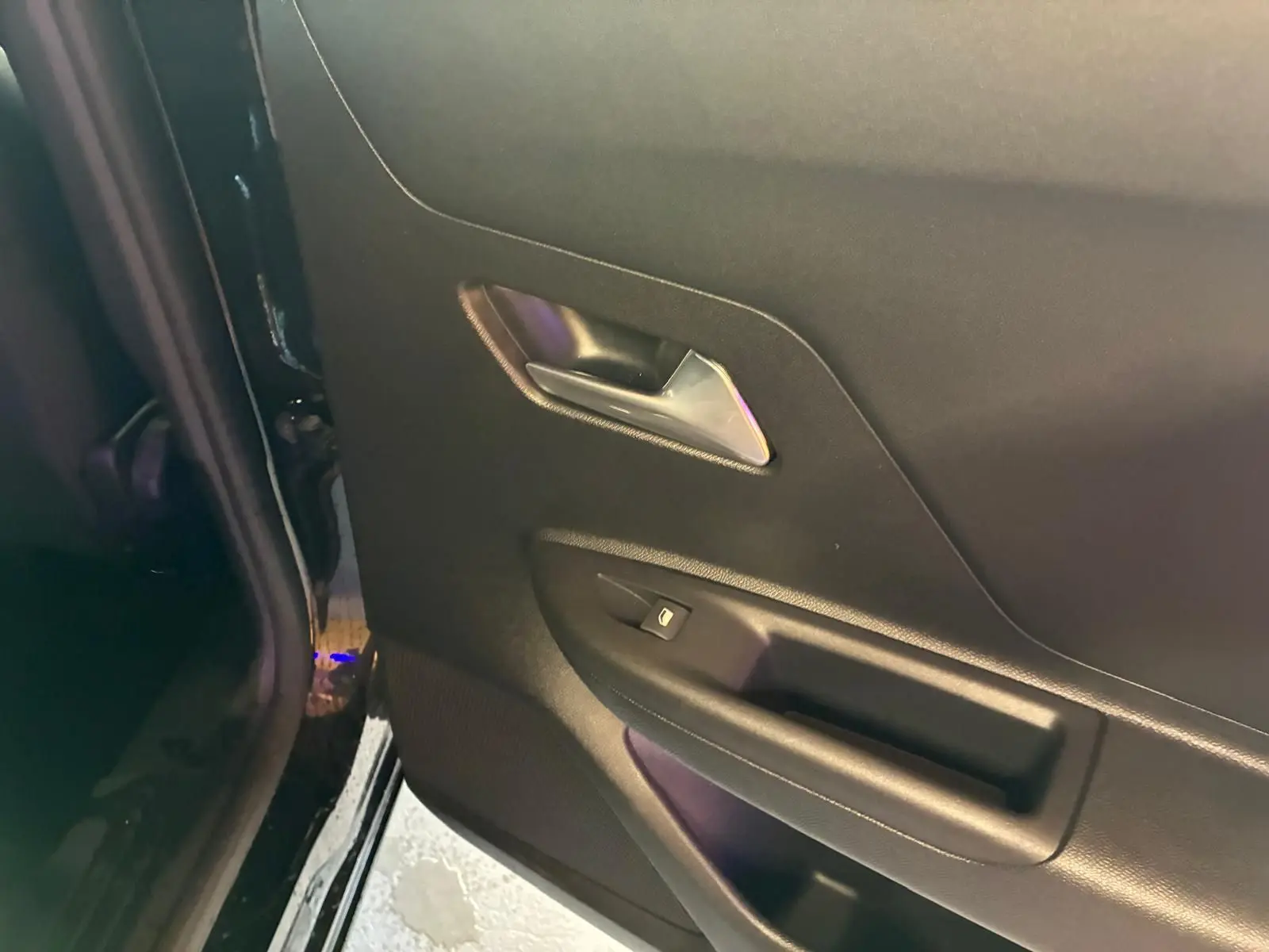 Gros plan sur la porte arrière gauche noire de l’Opel Mokka 2025, avec poignée argentée et bouton de verrouillage.