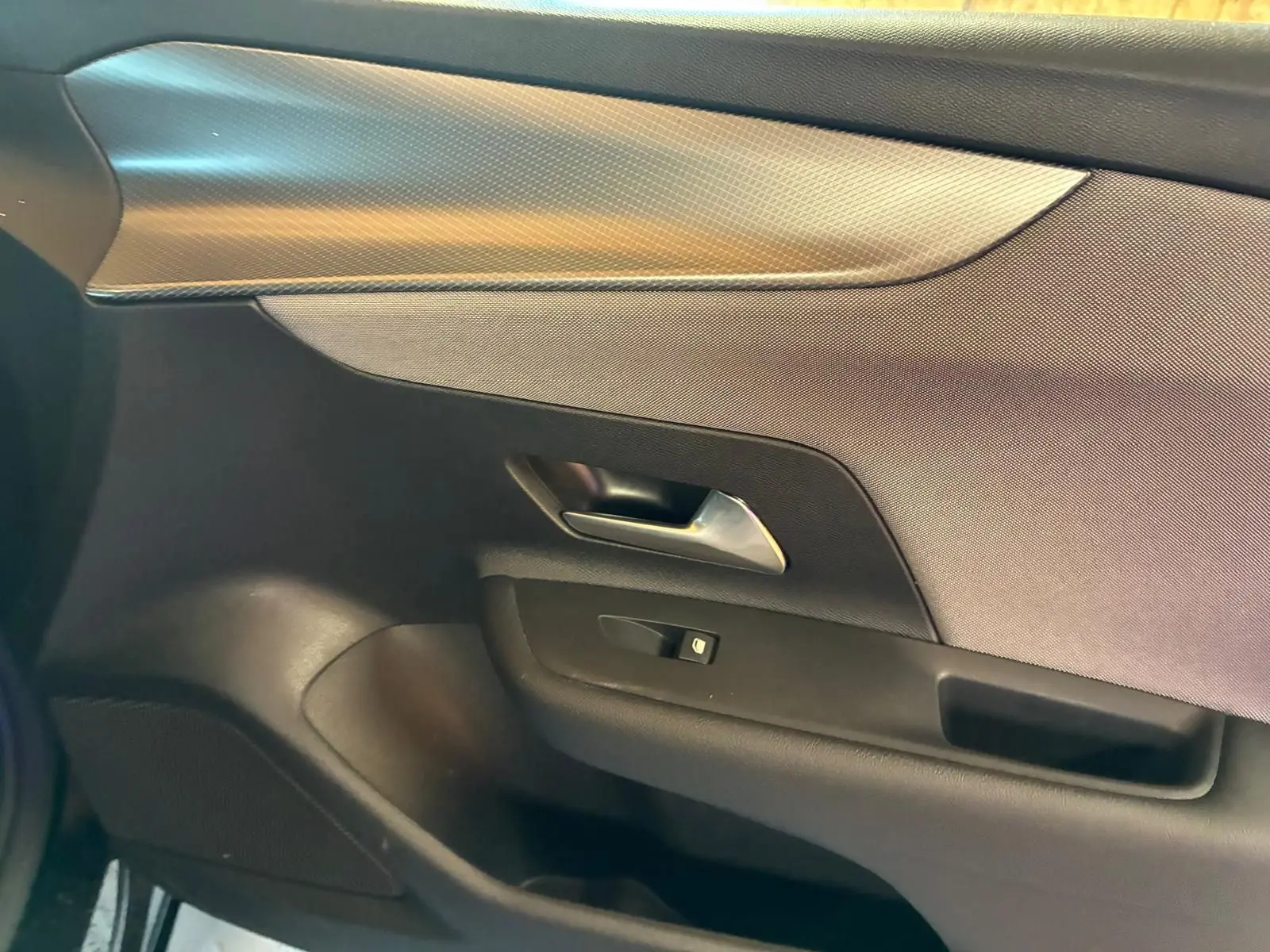 Détail de la porte intérieure côté gauche de l’Opel Mokka 2025, finition tissu noir avec poignée métallique.