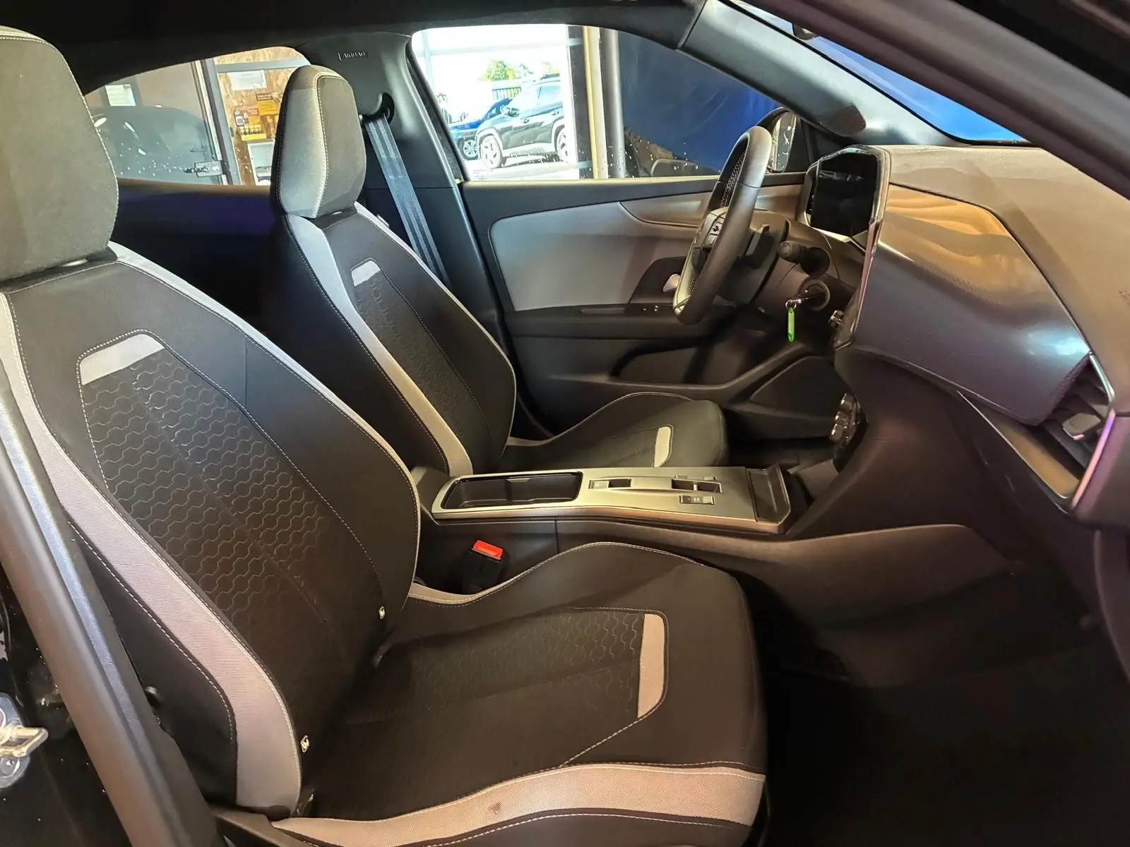 Vue intérieure côté droit de l'Opel Mokka 2025 noir, montrant les sièges tissu noirs et la console centrale moderne.