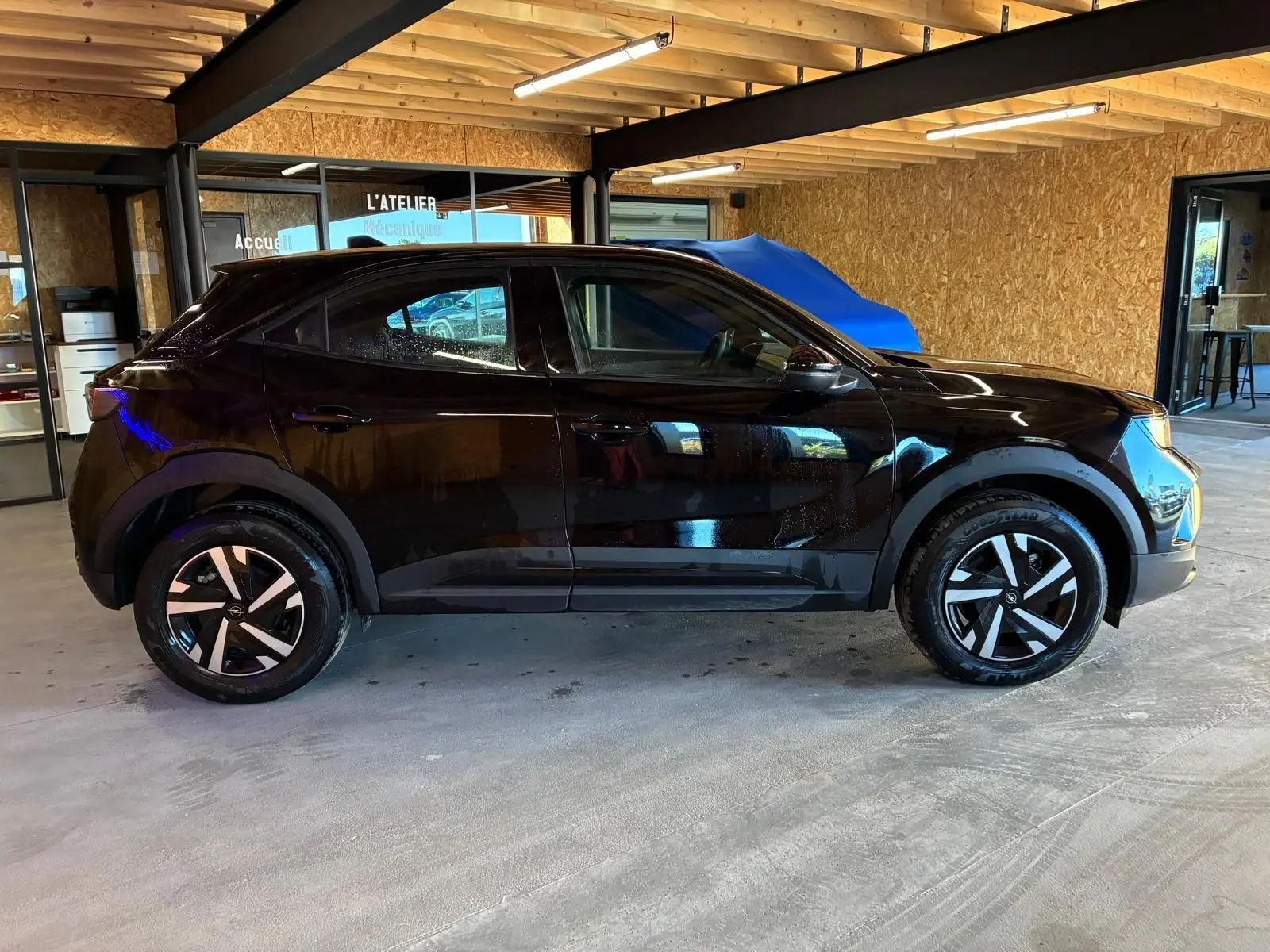 Opel Mokka 1.2 Turbo 145 Edition noir vue de profil côté gauche, avec jantes alliage et intérieur tissu noir visible.