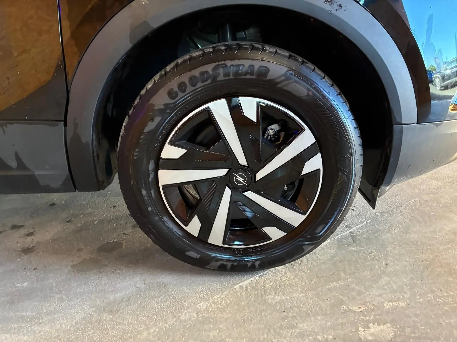 Gros plan sur la roue avant droite noire d’un Opel Mokka 2025 avec jante alliage au design géométrique bicolore.