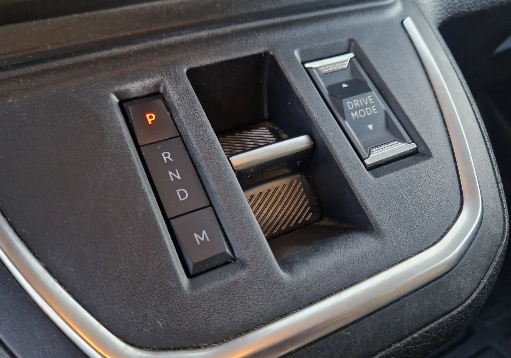 Gros plan sur la console centrale noire du Fiat Scudo Fourgon 2024, avec boutons de boîte auto et mode de conduite.