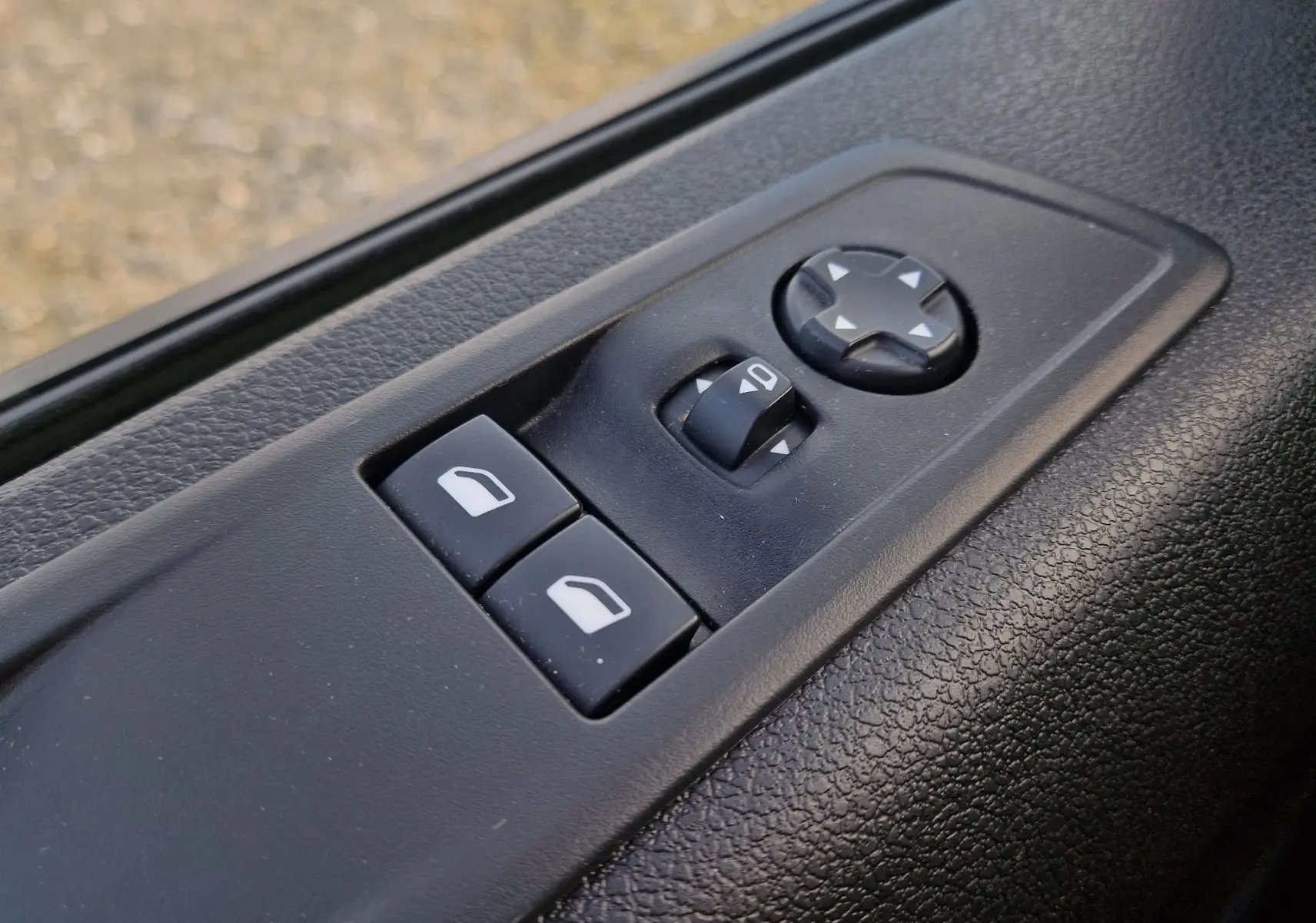 Commande des rétroviseurs et vitres électriques sur la porte intérieure côté conducteur du FIAT Scudo Fourgon blanc 2024.
