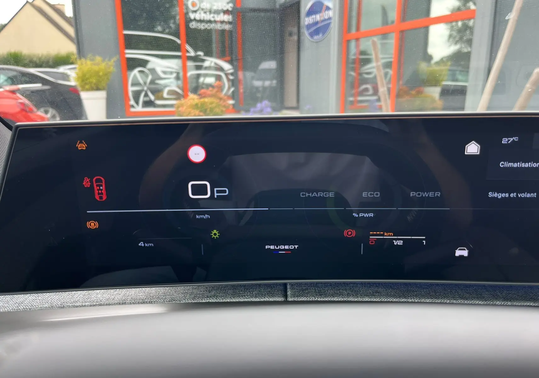 Affichage numérique du tableau de bord du Peugeot 3008 gris titane, avec indicateurs de charge et vitesse à l'arrêt.