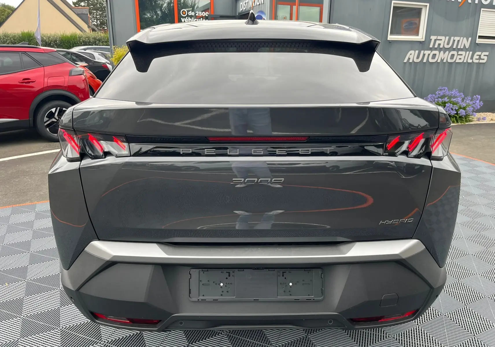 Vue arrière d'un Peugeot 3008 Nouveau gris titane avec feux LED distinctifs et toit noir brillant.