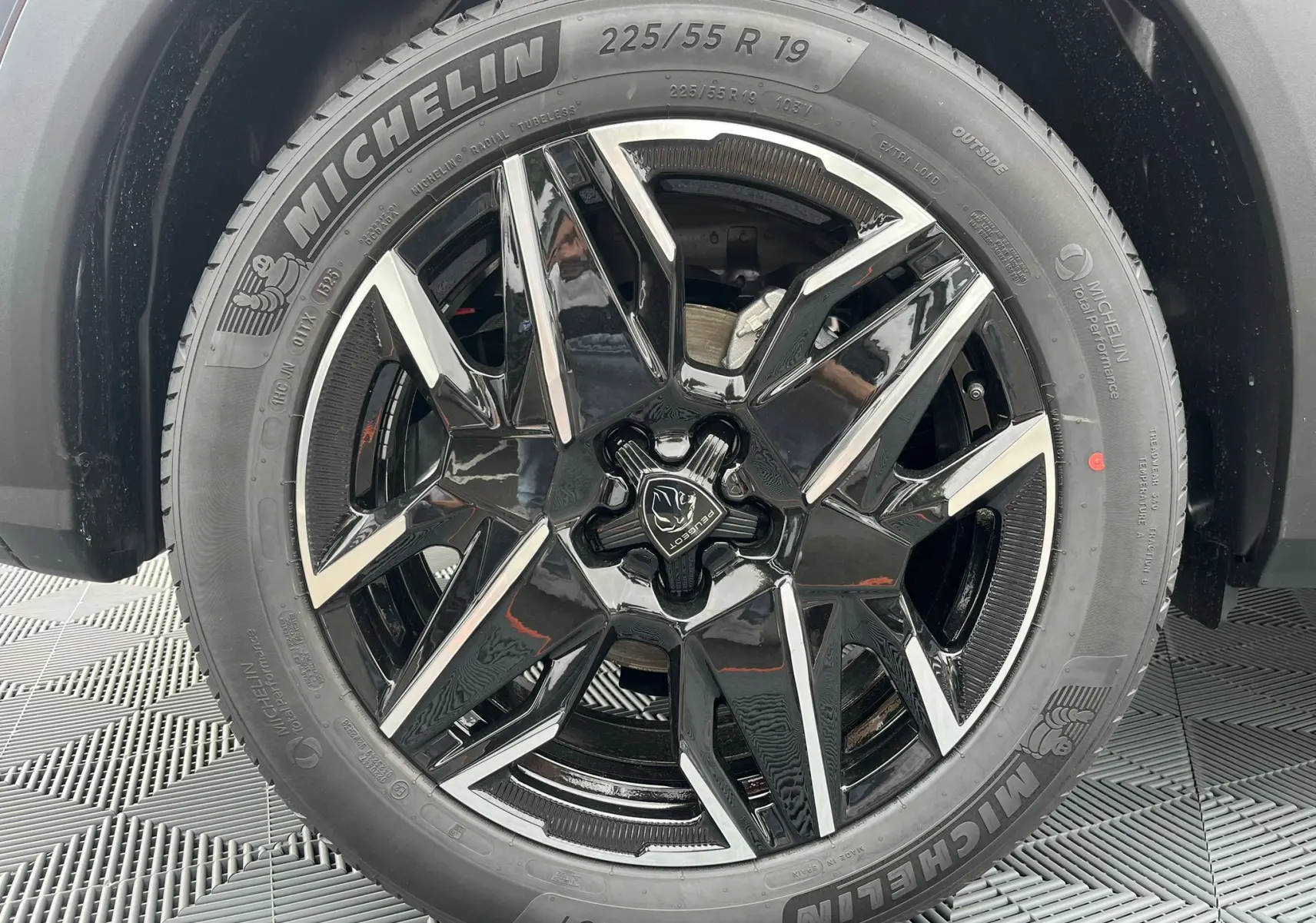 Gros plan sur la jante alliage 19'' diamantée noire du Peugeot 3008 Nouveau gris titane avec pneu Michelin visible.
