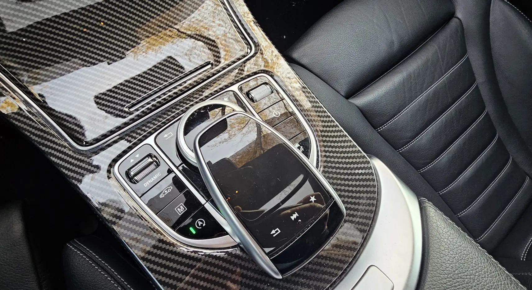 Gros plan sur la console centrale en carbone et le cuir noir des sièges du Mercedes GLC Coupé blanc 2018.