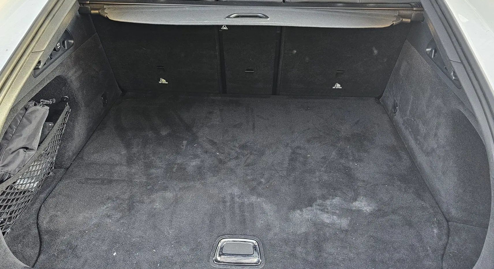 Coffre ouvert d'une Mercedes GLC 220 Coupé blanc de 2018, montrant un espace de chargement propre et tapissé noir.