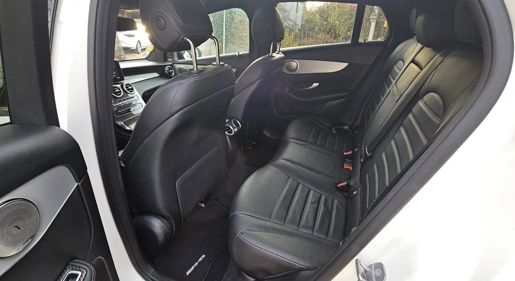 Vue intérieure côté droit montrant les sièges arrière en cuir noir du Mercedes GLC 220 Coupé blanc 2018.