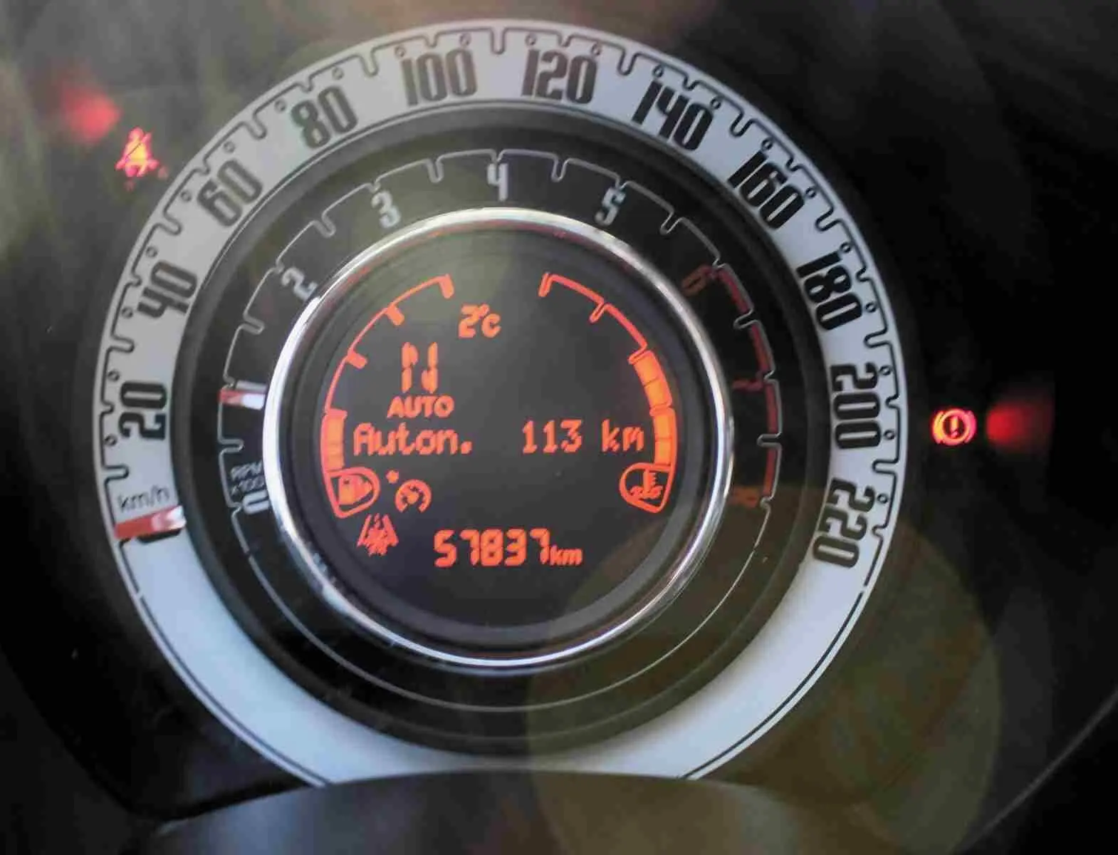 Vue rapprochée du compteur de vitesse digital de la Fiat 500C 2018, affichant 57 837 km et autonomie 113 km.