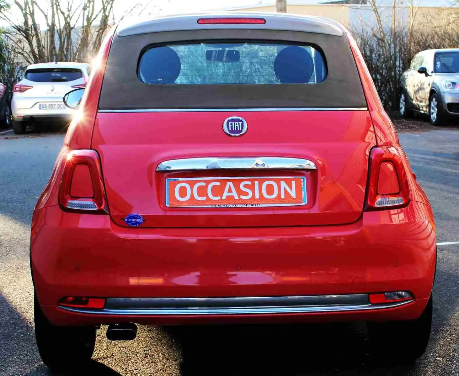 Vue frontale d'une FIAT 500C Pastel Coral Red 2018 avec toit ouvrant et plaque orange "OCCASION" visible.