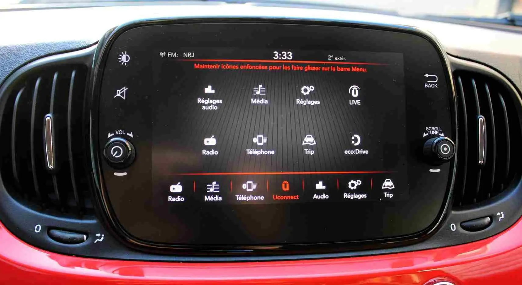 Écran tactile central de la FIAT 500C 2018 en Pastel Coral Red, avec commandes audio et ventilation visibles.