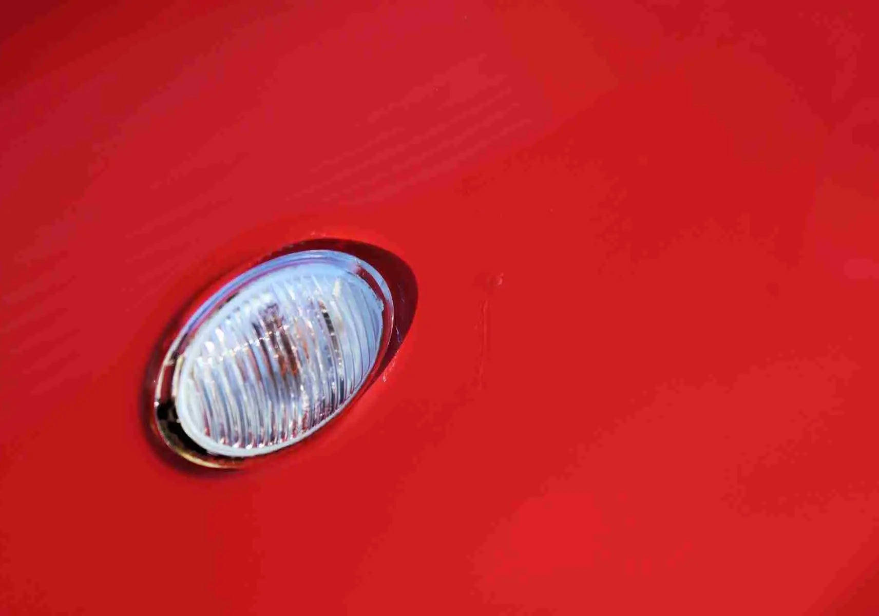 Gros plan sur le clignotant avant droit de la FIAT 500C 2018 en rouge Pastel Coral Red.