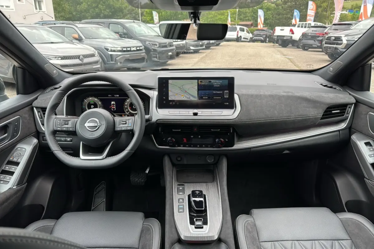 Vue intérieure avant du Nissan Qashqai E-POWER 205 Tekna Plus, tableau de bord moderne avec écran central et volant cuir multifonctions.