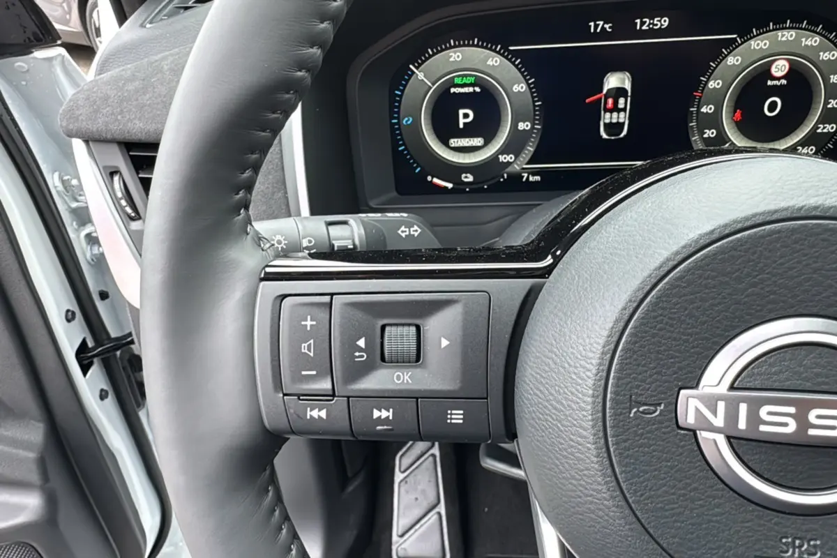 Gros plan sur le volant cuir noir du Nissan Qashqai E-POWER 205 Tekna Plus avec tableau de bord numérique affichant 7 km.