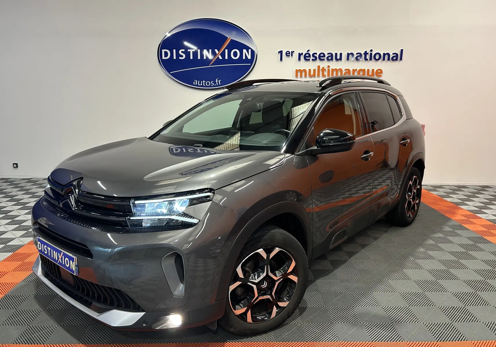Citroën C5 Aircross gris Platinium en 3/4 avant droit, avec jantes noires et éclairage LED allumé.