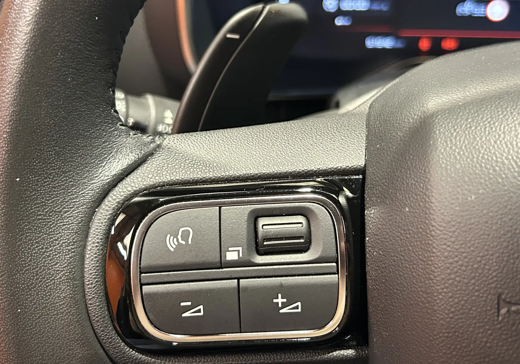 Gros plan sur les commandes de volume et téléphone au volant noir du Citroën C5 Aircross 2023, finition Shine.