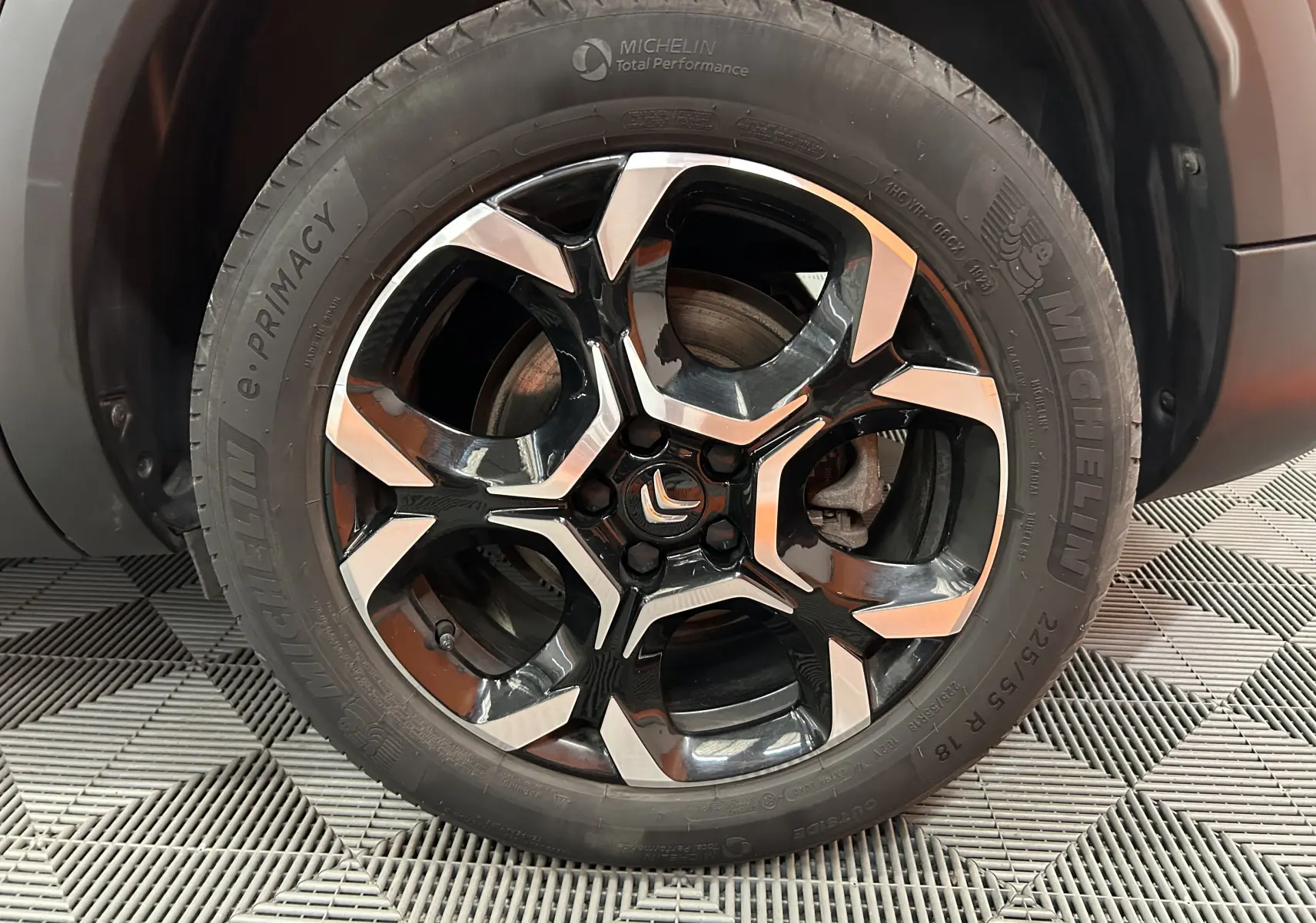 Gros plan sur la roue avant droite d’un Citroën C5 Aircross gris Platinium avec jante alliage noire et argentée.