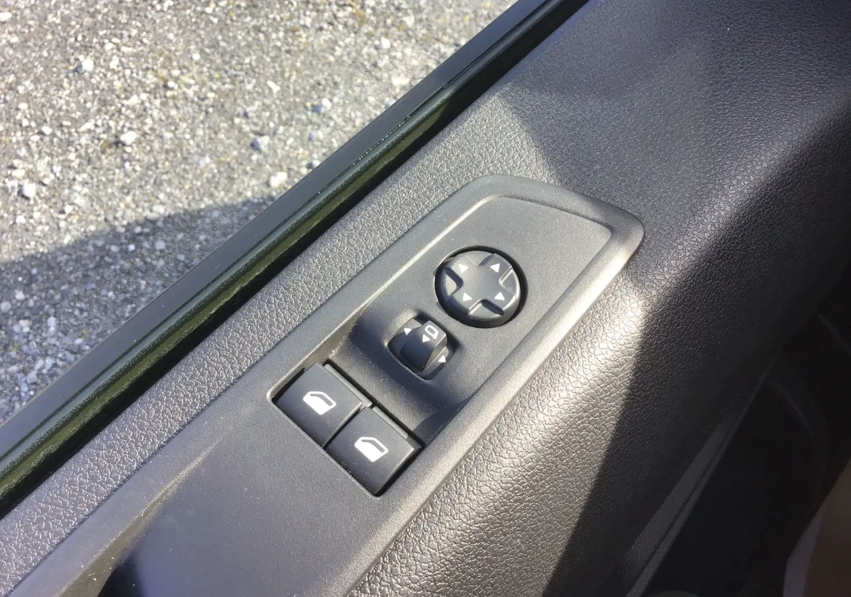 Commande des rétroviseurs et des vitres électriques sur la portière côté conducteur du FIAT Scudo Fourgon blanc, intérieur noir.