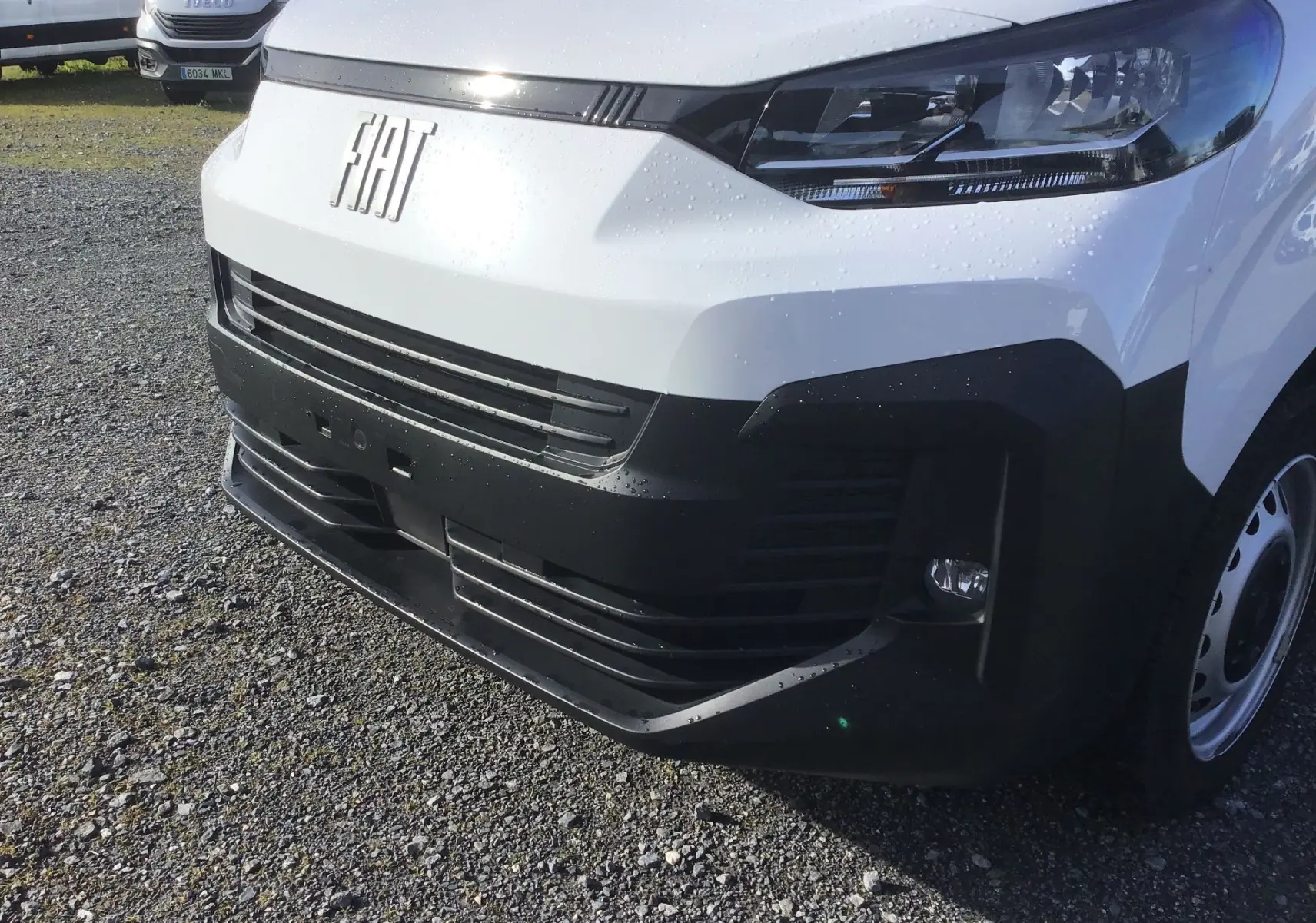 Gros plan sur l'avant droit du FIAT Scudo Fourgon blanc 2024 avec calandre noire et phares modernes.