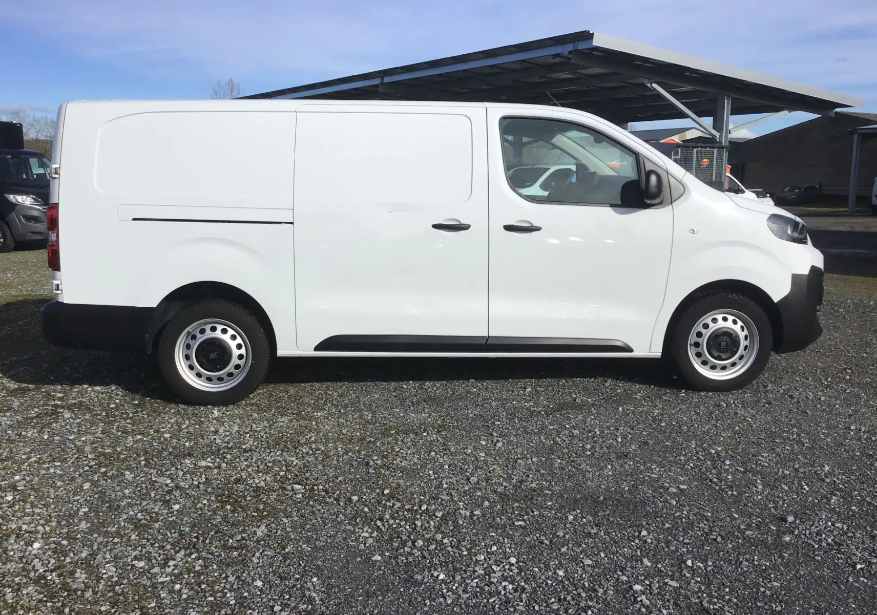 Vue de profil côté droit d’un FIAT Scudo Fourgon blanc 2024 avec portes latérales coulissantes et jantes acier.