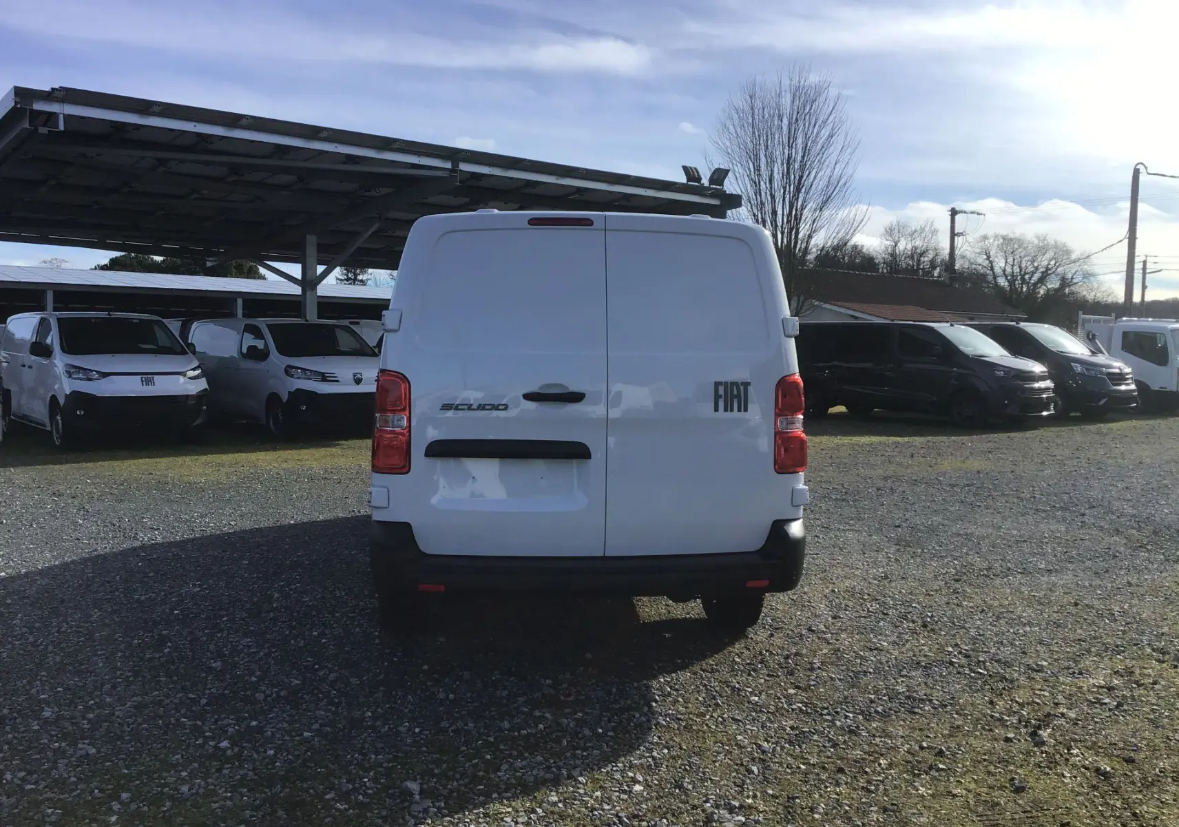 Vue arrière d’un FIAT Scudo Fourgon blanc 2024, avec portes battantes fermées et logo FIAT visible à droite.