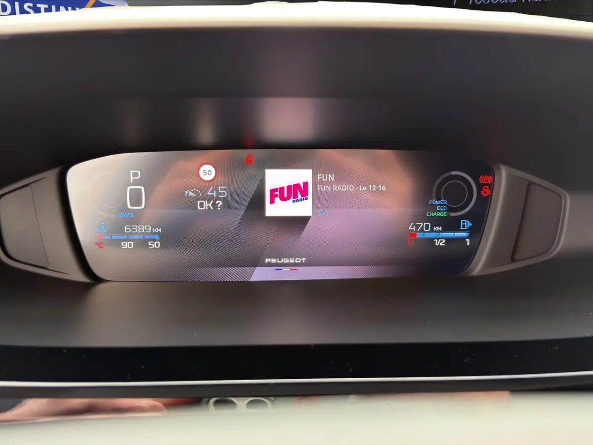 Affichage numérique du combiné instruments de la Peugeot 308 Hybrid 145 e-DCS6 Allure, avec radio FUN et indicateurs hybrides.