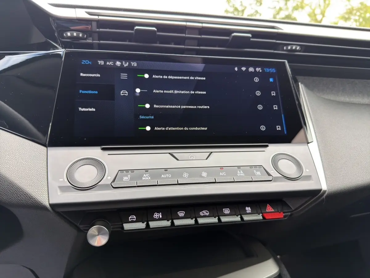 Vue rapprochée de l'écran tactile central et des commandes de climatisation de la Peugeot 308 Hybrid 145 e-DCS6 Allure 2025.