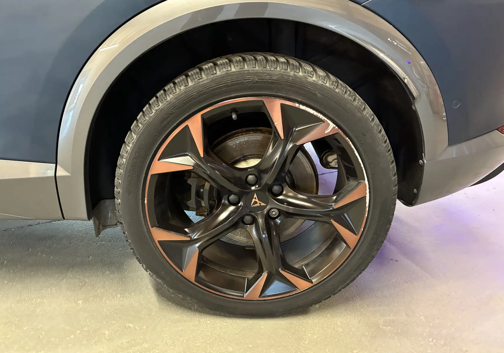Gros plan sur la jante alu noire et cuivre du côté arrière droit du CUPRA Formentor bleu 2023.